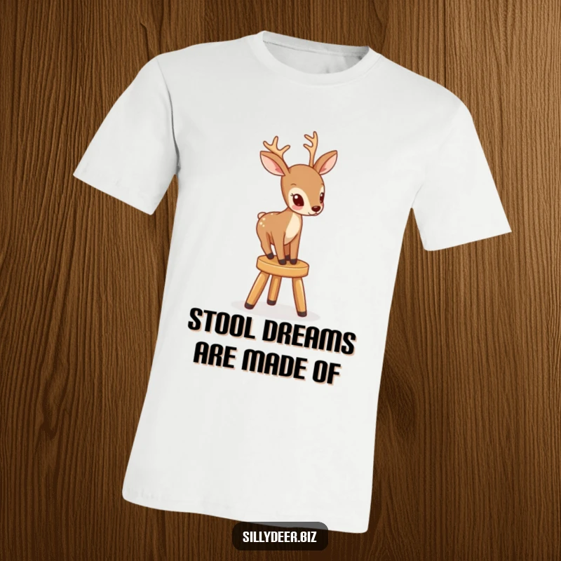 Funny t-shirt depicting a focused deer bravely attempting to climb a small, unsteady stool, showcasing its comical determination.